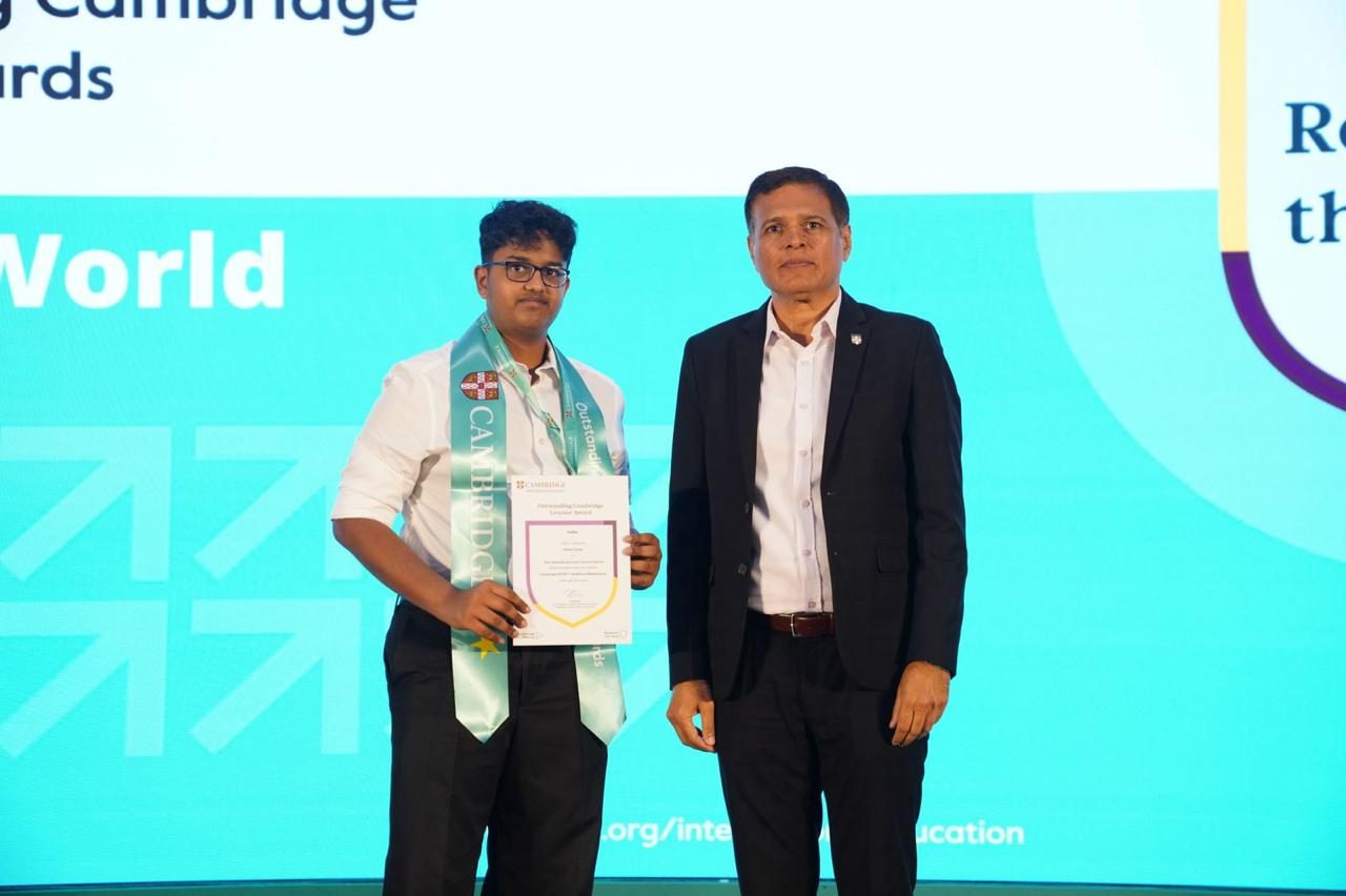 Holding the framed certificate beside the presenter at the Cambridge awards